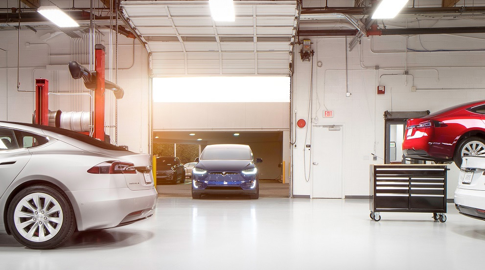 Image of Teslas being serviced in a service bay
